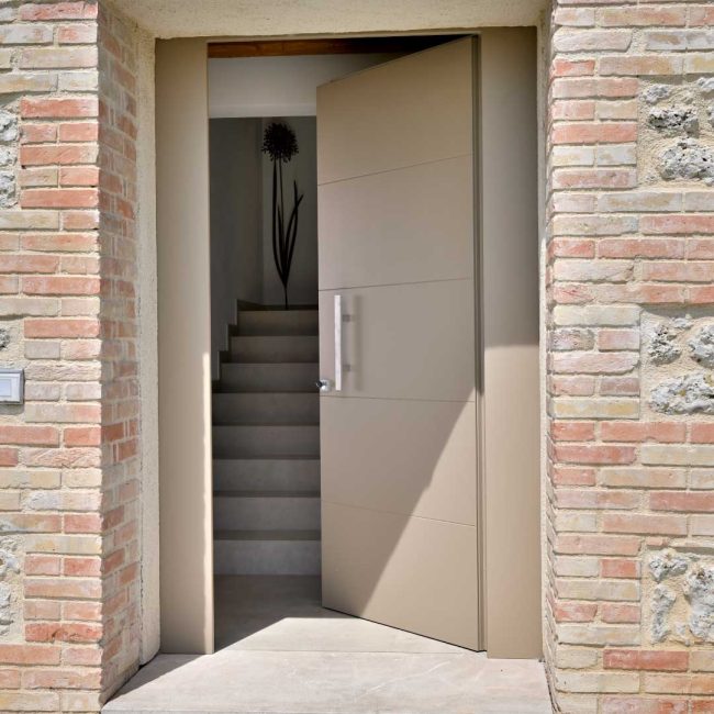 Portoncino in legno con laccatura bicolore interno/esterno. Falsa cassa a taglio termico con rete portaintonaco, traverso inferiore con parafreddo.