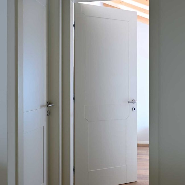 Porta interna laccata con specchiature in bassorilievo.