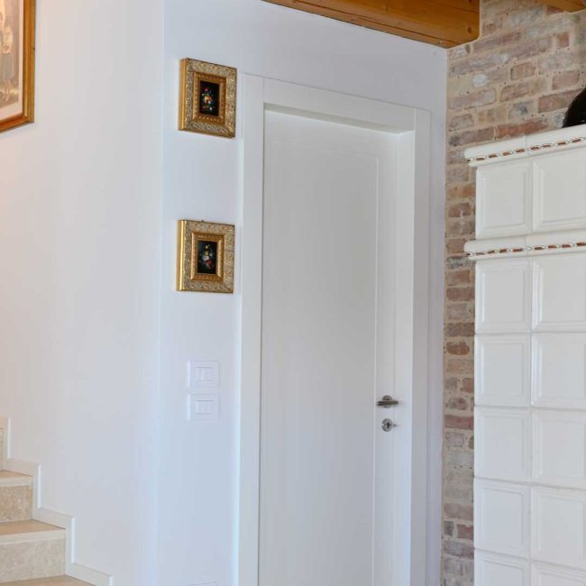 Porta interna laccata RAL 9010 con specchiature.