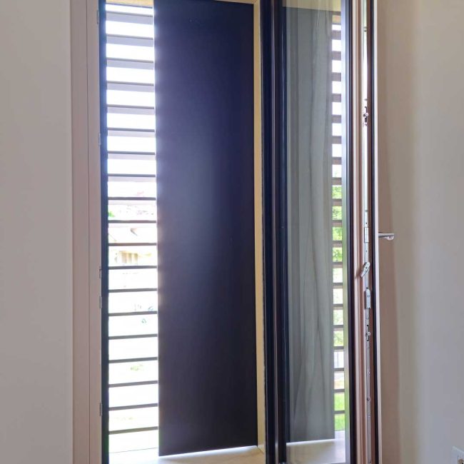 Porta finestra in legno alluminio con scuro scorrevole motorizzato RAL 8019.