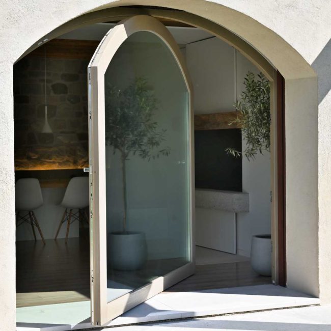 Porta finestra ad arco con apertura a bilico verticale.
