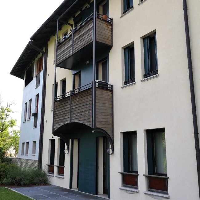 Parapetto esteno rivestito in legno per una palazzina a Sacile.
