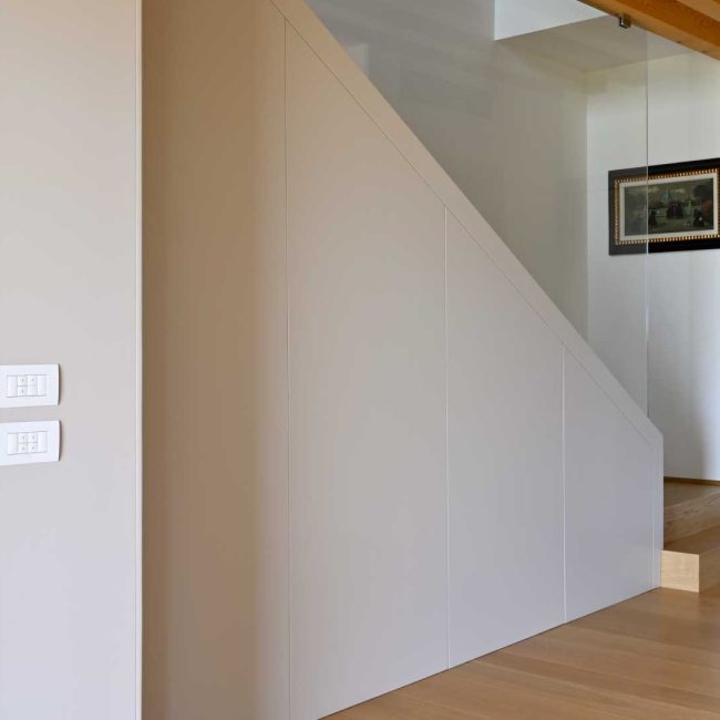 Tamponamento scala in legno laccato NCS S 1502Y50R. Parapetto in vetro con pinze in acciaio inox. Pavimento in rovere naturale leggermente spazzolato.