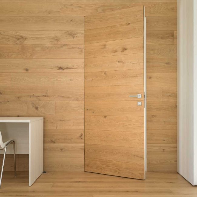 Rivestimento parete interna con tavole. Porta a filo rivestita con le stesse tavole.