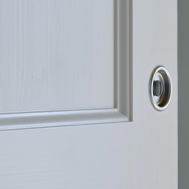 Particolare porta interna scorrevole laccata con specchiature e finitura a pennello.