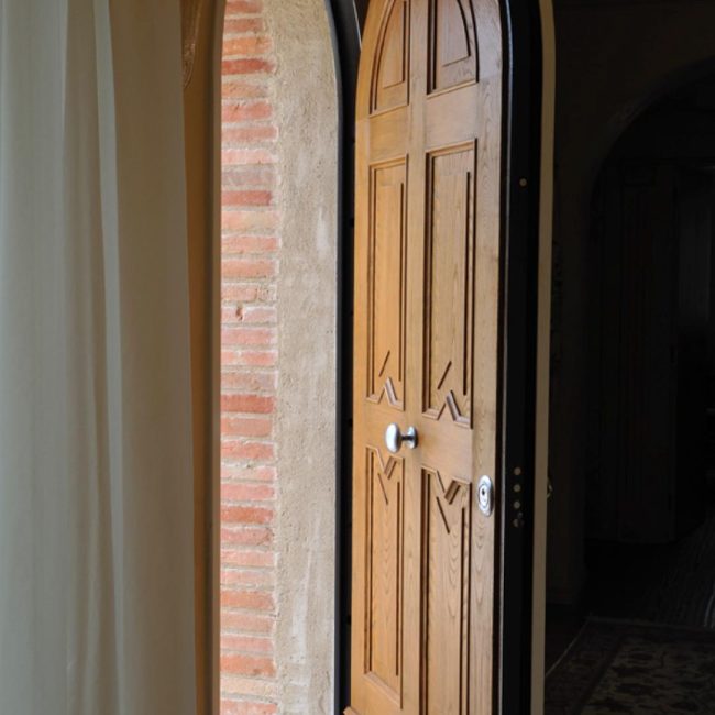 Portoncino blindato ad arco con intarsi a disegno.