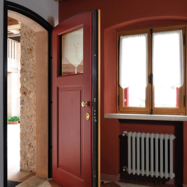 Portoncino blindato bicolore con specchiature e parte vetrata.