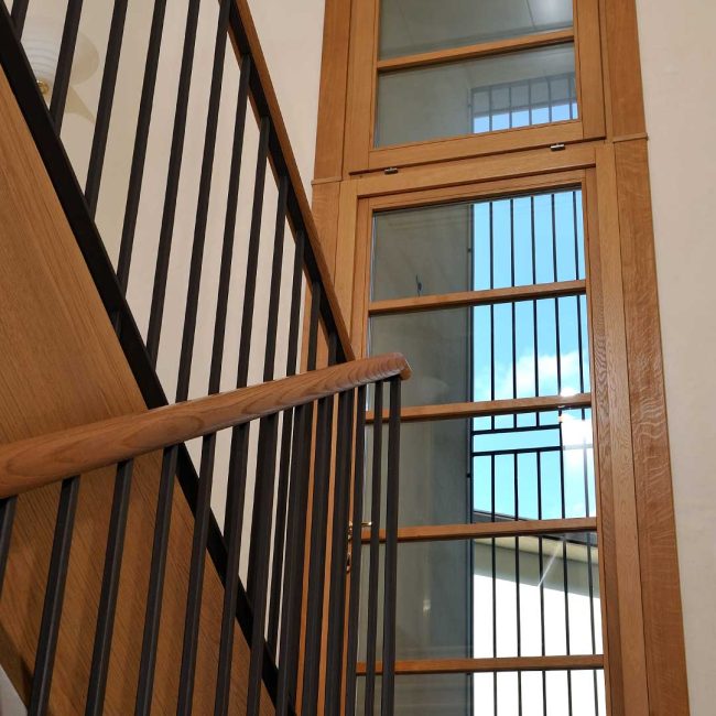 Porta finestra su scala in rovere e finestra con apertura motorizzata.