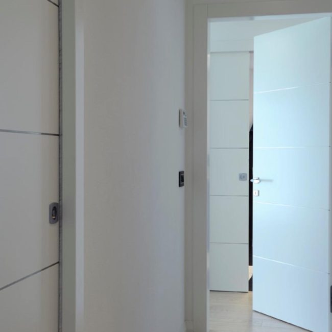 Porte interne laccate a battente e scorrevoli con inserti in acciaio inox
